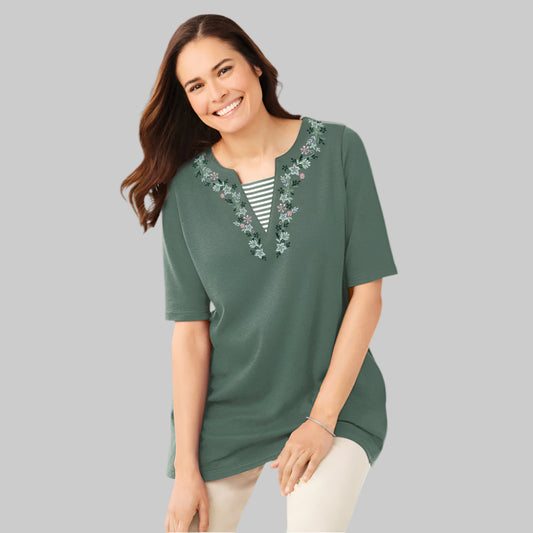Plus-size 2-in-1 tunic with a notch neckline, striped contrast inset, and embroidered detail. Relaxed fit with elbow-length sleeves and a 30” tunic length.