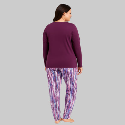 Plus-size woman wearing a plum long-sleeve pajama top with printed pocket and multicolor abstract print pajama bottoms — cozy cotton-blend sleepwear set.