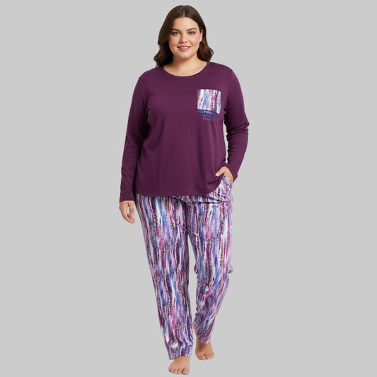 Plus-size woman wearing a plum long-sleeve pajama top with printed pocket and multicolor abstract print pajama bottoms — cozy cotton-blend sleepwear set.