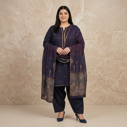 Woman wearing a traditional outfit with a dark purple kurta and pants against a beige background