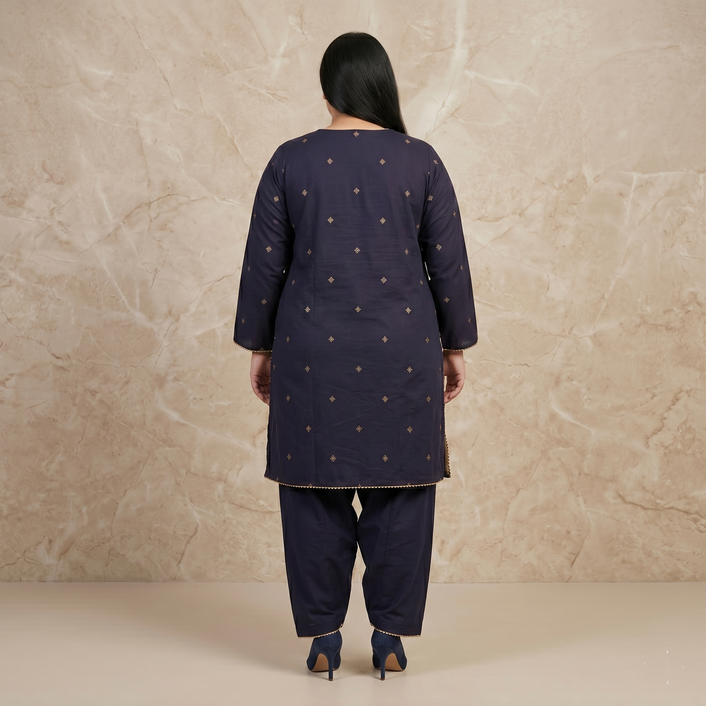 Woman wearing a navy blue traditional outfit with gold patterns against a beige background