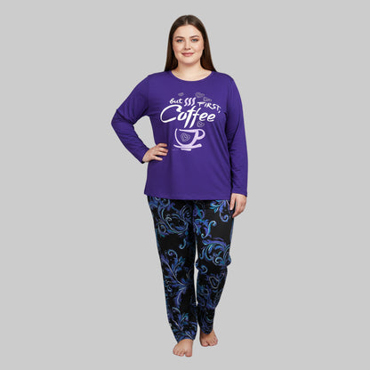 Plus-size woman wearing a purple long-sleeve pajama top with “But First, Coffee” print and printed pajama bottoms — cozy cotton-blend sleepwear set.