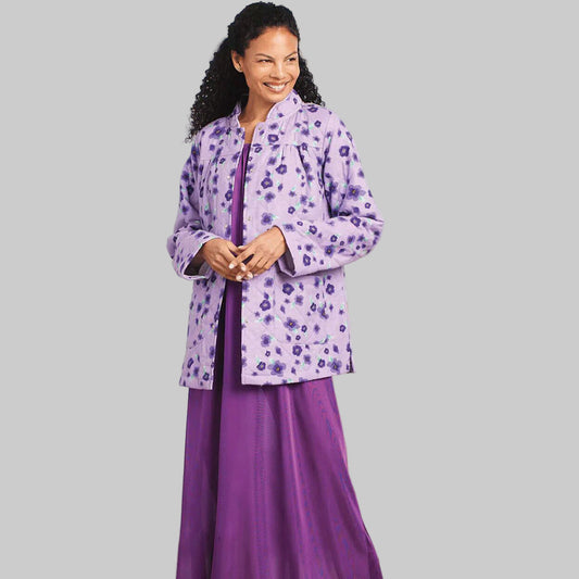 Plus-size model wearing purple floral flannel snap-button jacket on a light studio background, front view.