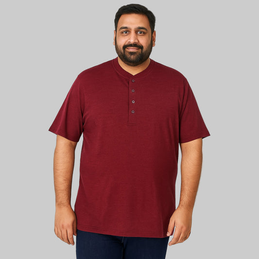 Plus-size Pakistani male model wearing rich burgundy Henley T-shirt on a light studio background, relaxed fit, 4-button placket.