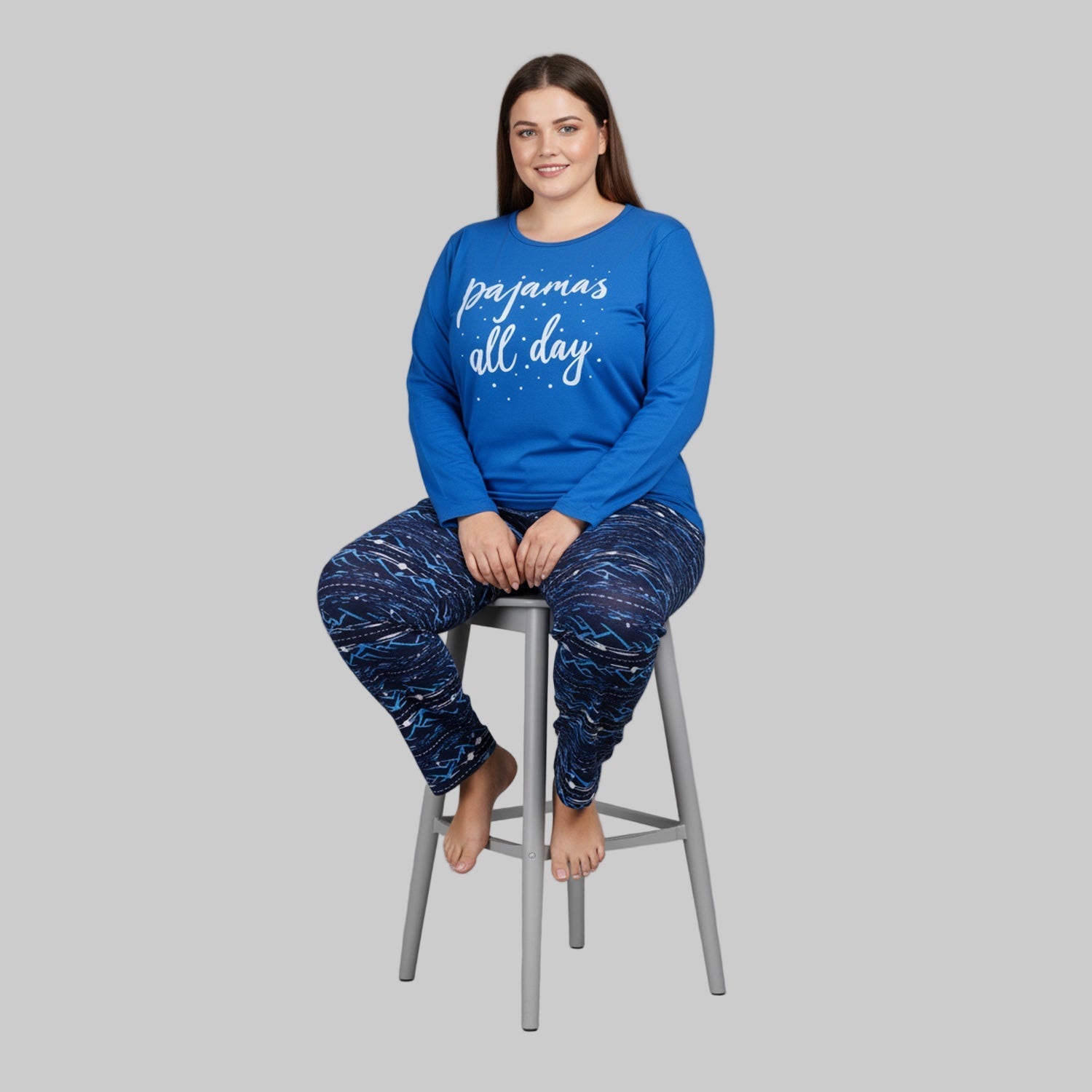 Plus-size woman wearing royal blue “Pajamas All Day” long-sleeve top with printed navy blue pajama bottoms — soft cotton-blend sleepwear set.