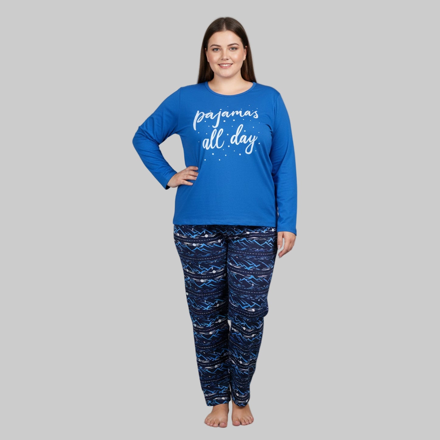 Plus-size woman wearing royal blue “Pajamas All Day” long-sleeve top with printed navy blue pajama bottoms — soft cotton-blend sleepwear set.