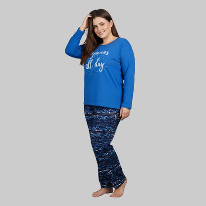 Plus-size woman wearing royal blue “Pajamas All Day” long-sleeve top with printed navy blue pajama bottoms — soft cotton-blend sleepwear set.