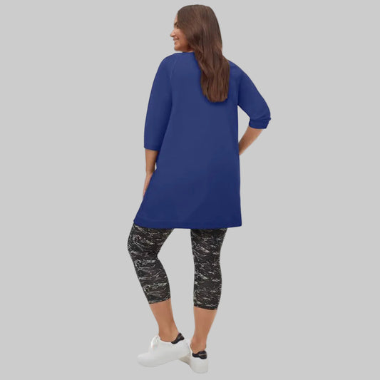 Royal cobalt French terry tunic with raglan sleeves, ribbed detailing, slanted zip pockets, and mid-thigh length shown on a plain background.