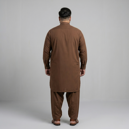 Man wearing a brown traditional outfit against a gray background