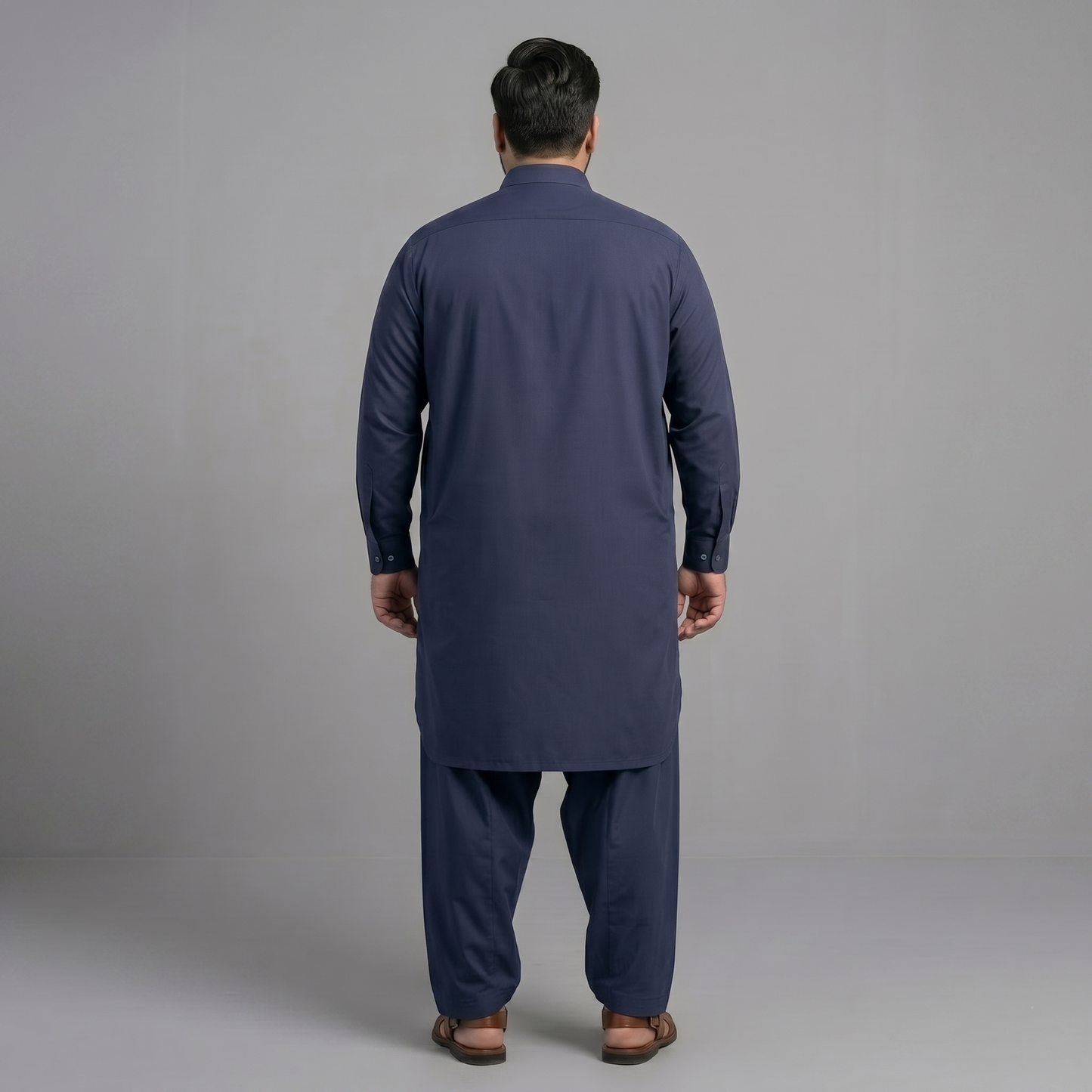 Man wearing a navy blue kurta set against a gray background