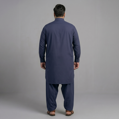 Man wearing a navy blue kurta set against a gray background