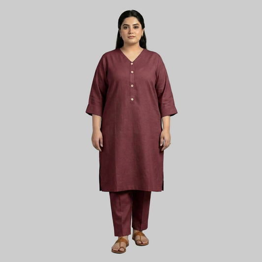 Woman wearing a maroon kurta with pants on a gray background