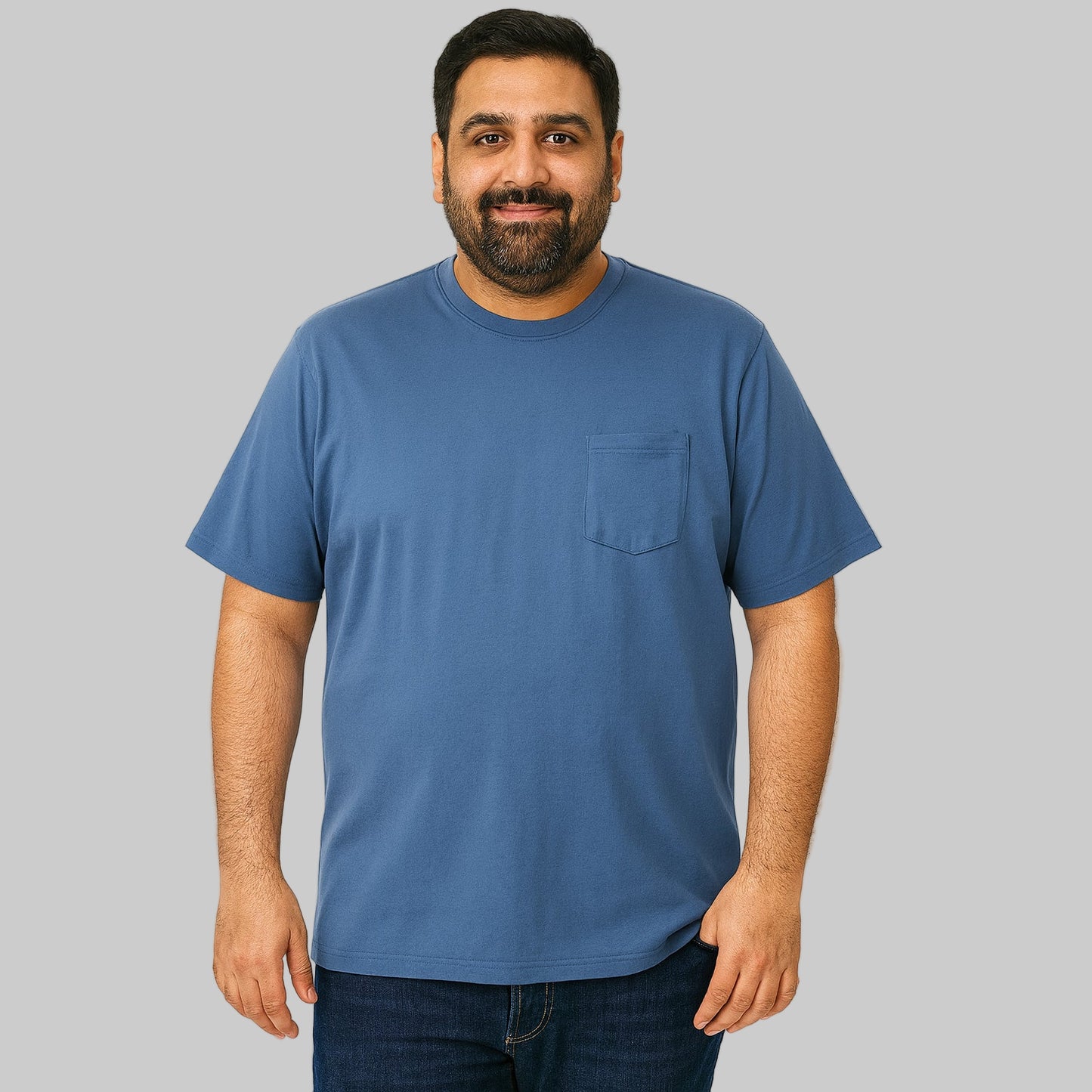 Plus-size Pakistani male model wearing slate blue crewneck T-shirt on a clean studio background, relaxed fit.