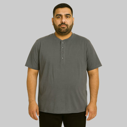 Plus-size Pakistani male model wearing steel short-sleeve Henley shirt on a clean studio background, relaxed fit.