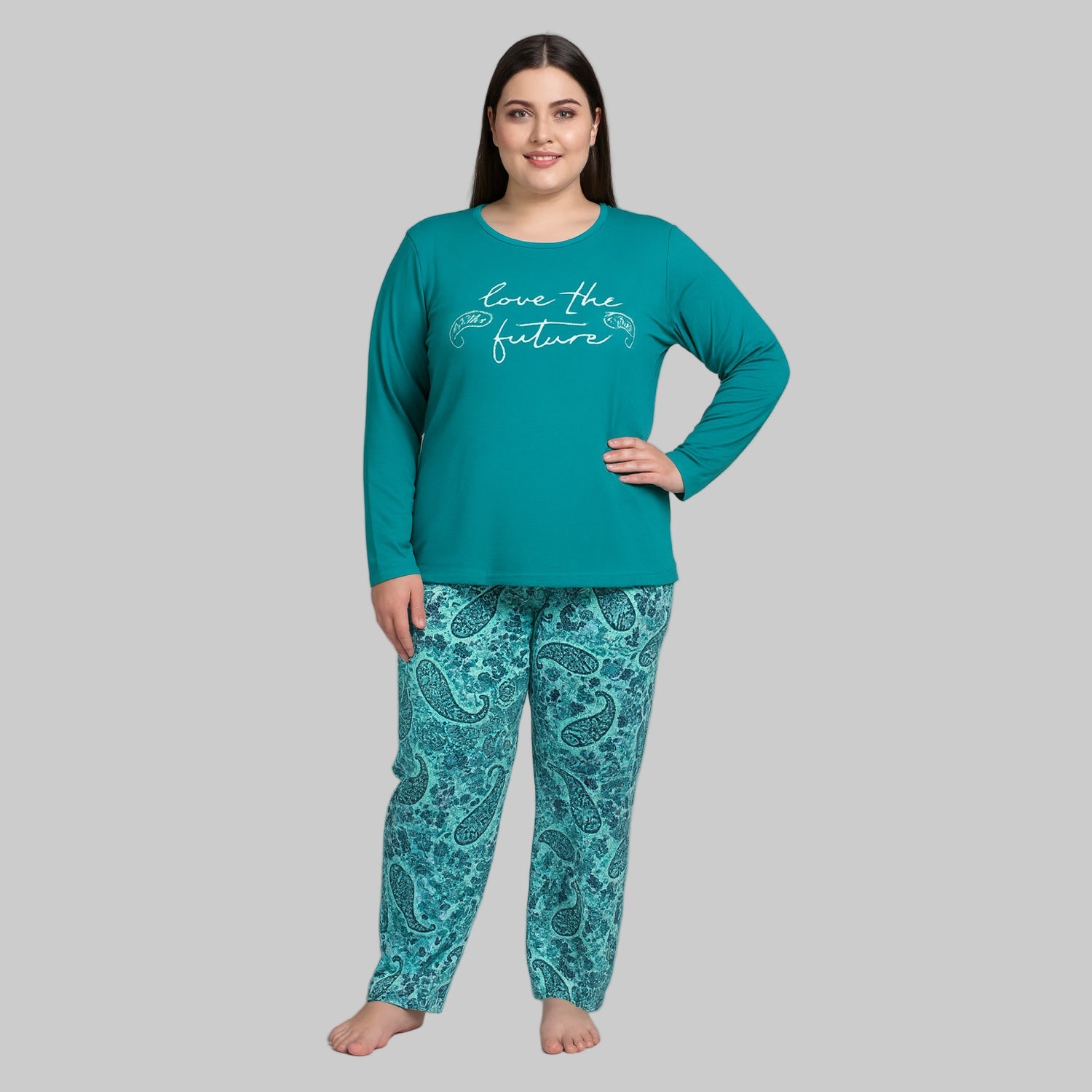 Plus-size woman wearing a teal long-sleeve pajama top with “Love the Future” print and teal paisley pajama bottoms — cozy cotton-blend sleepwear set.