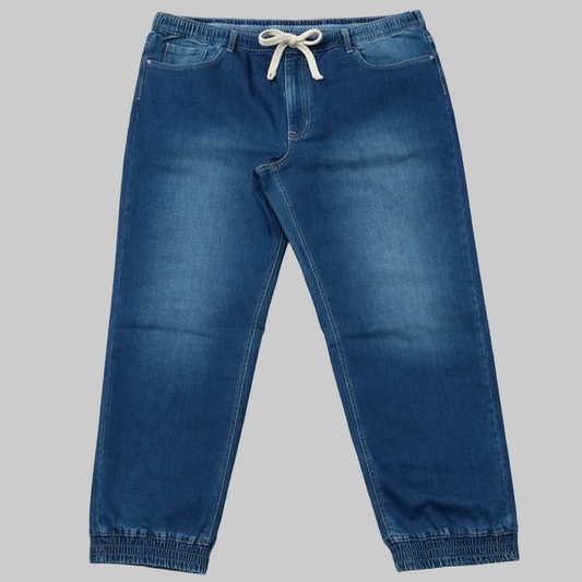 Blue denim jogger pants with elastic waistband, drawstring closure, and jogger cuffs on a clean white background.