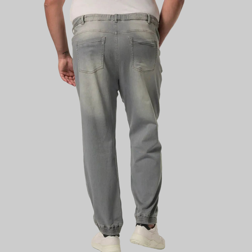 UrbanAsh Comfort Denim Joggers Jeans in a dark ash-grey wash, featuring a relaxed jogger fit with tapered legs, soft stretch denim fabric, elastic waistband with drawstring, ribbed cuffs, side pockets, and a modern casual streetwear look