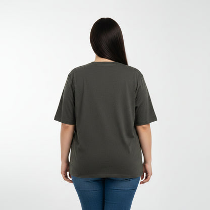 Woman wearing a dark green t-shirt and blue jeans on a white background