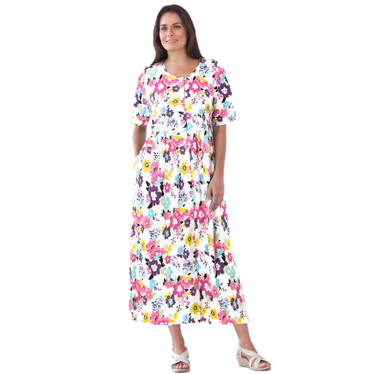 Woman wearing white floral garden print button-front dress with elbow sleeves and flowing skirt