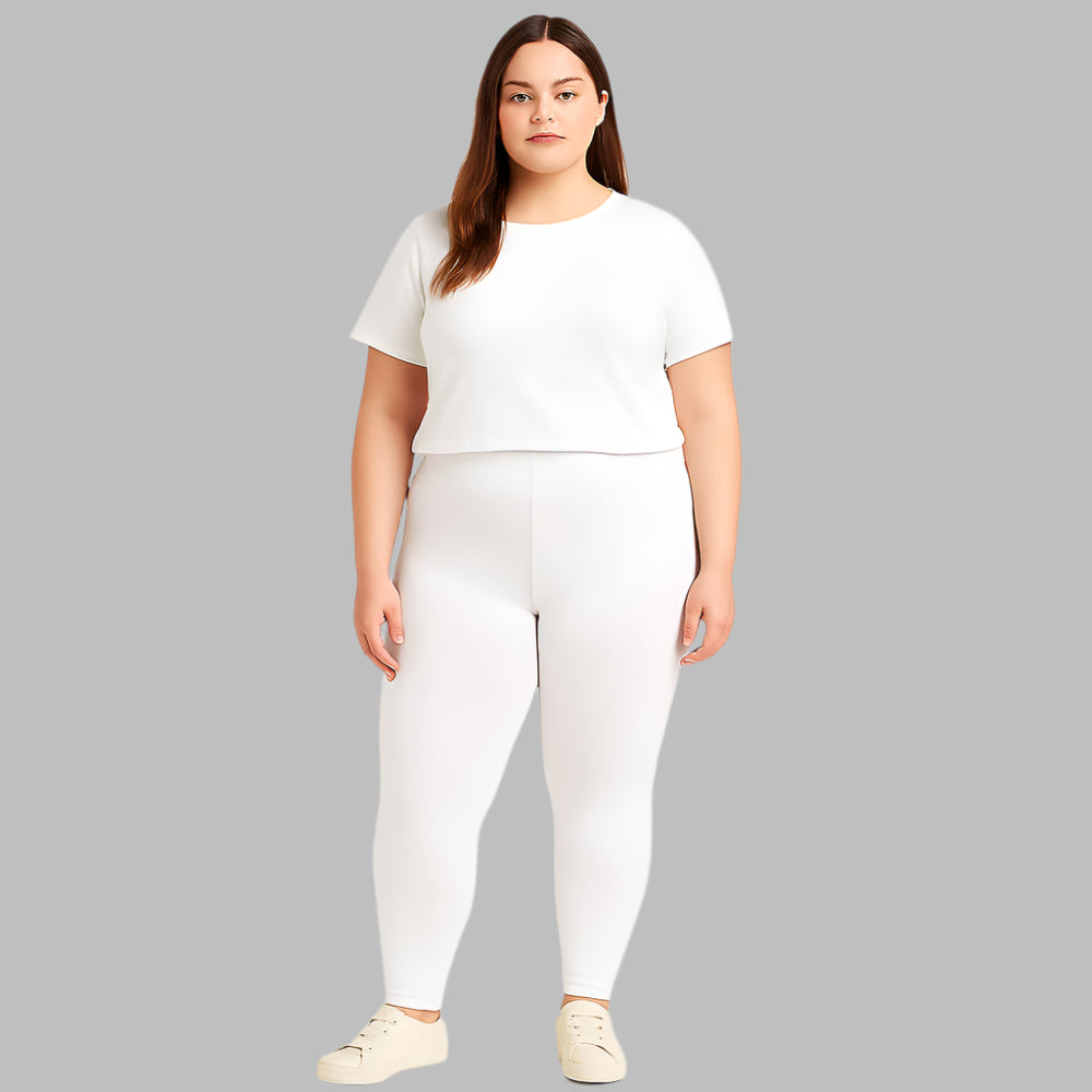 Plus size woman wearing high-rise white performance activewear leggings in studio