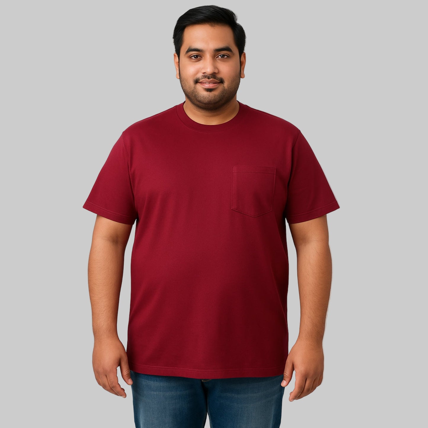 Plus-size male model wearing wine-colored crewneck pocket T-shirt, relaxed fit, front view, studio background.
