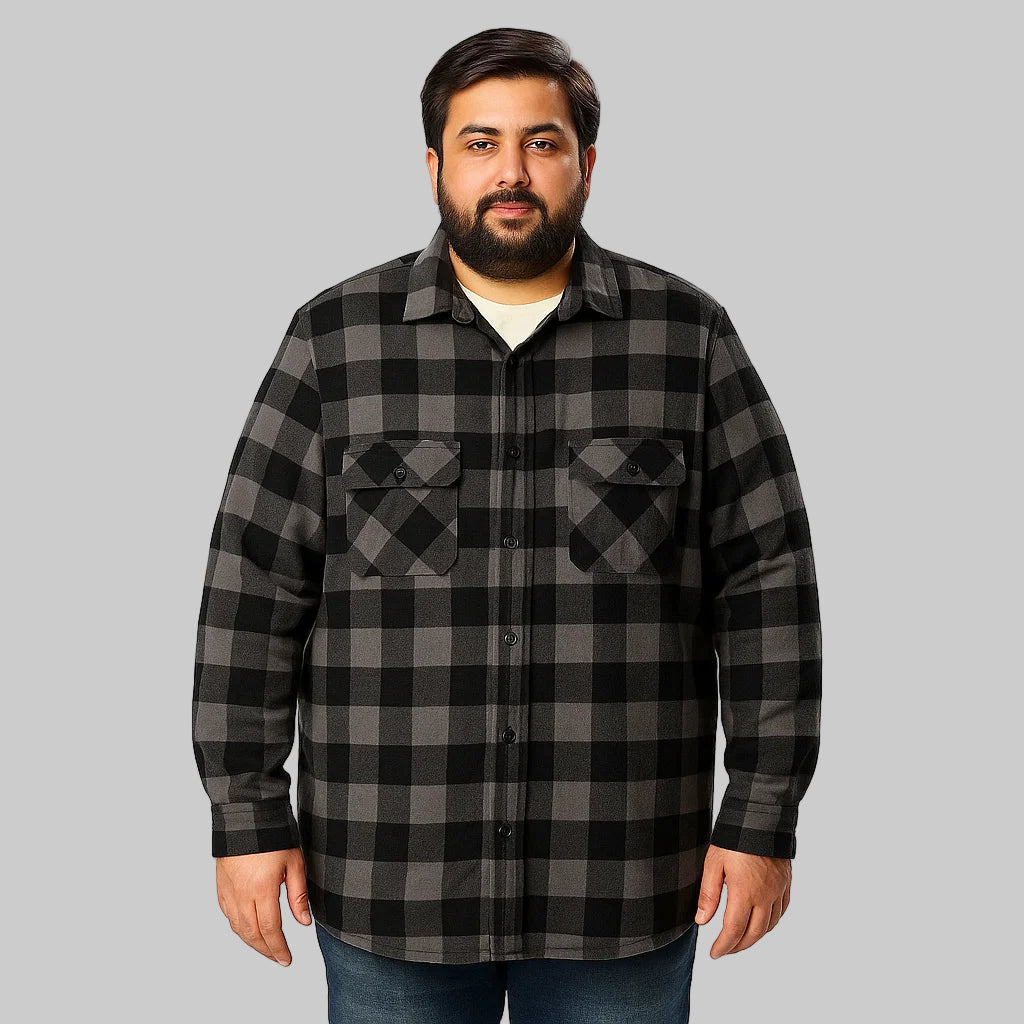 Plus-size Pakistani male model wearing black buffalo plaid sherpa-lined flannel jacket on a light studio background, front view, warm winter layer.