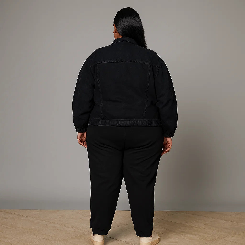 Plus-size woman wearing black denim jacket with flap pockets and button closure


