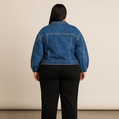Plus-size woman wearing classic blue denim jacket with elastic hem and button-front