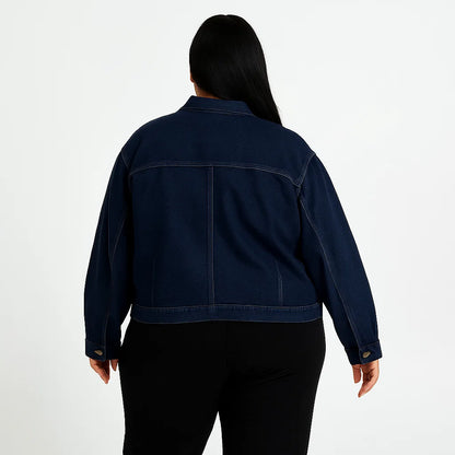 Plus-size woman wearing dark wash denim jacket with button front and flap chest pockets

