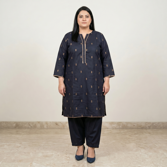 Woman wearing a dark blue kurta with gold patterns on a plain background