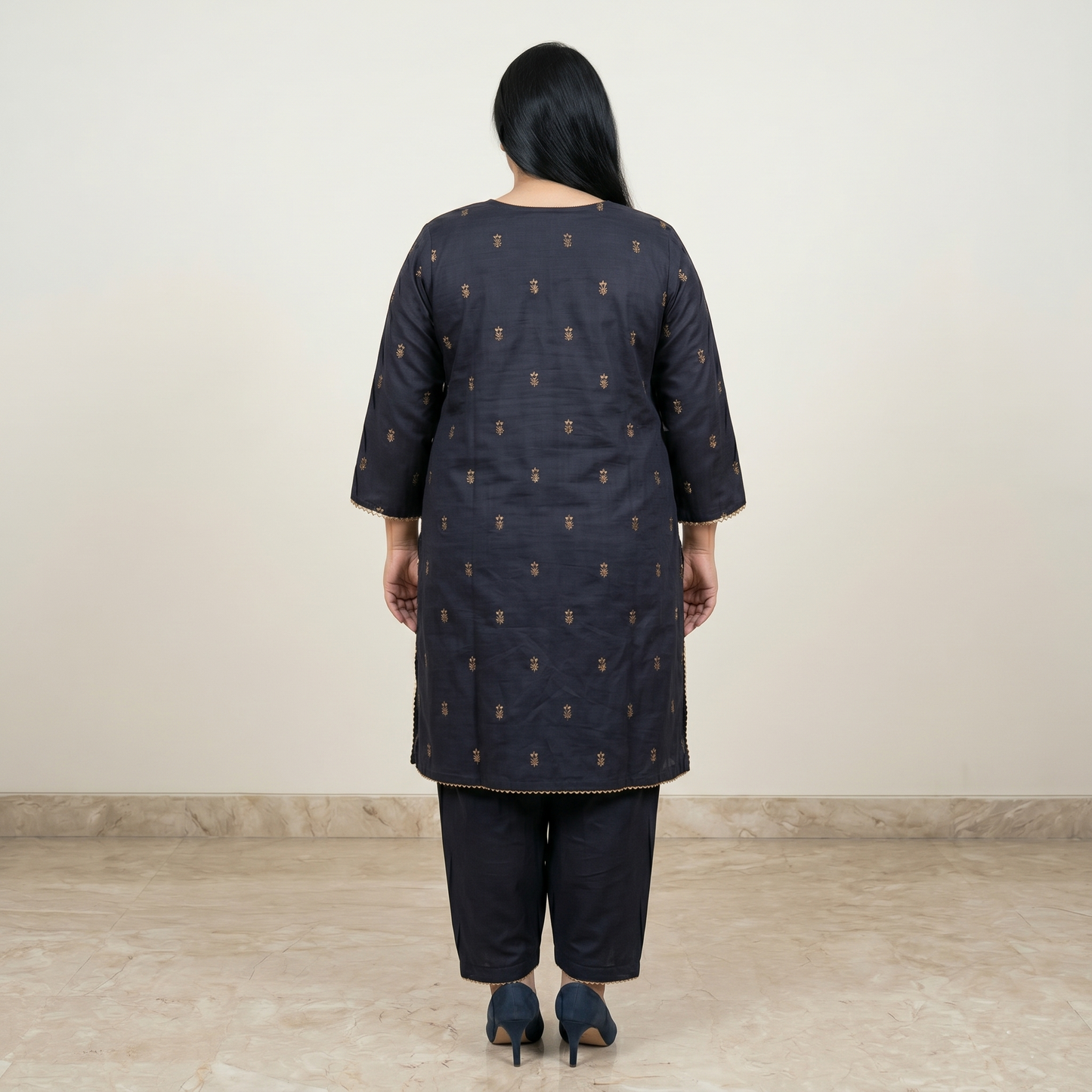 Woman wearing a dark blue kurta with a subtle pattern on a plain background