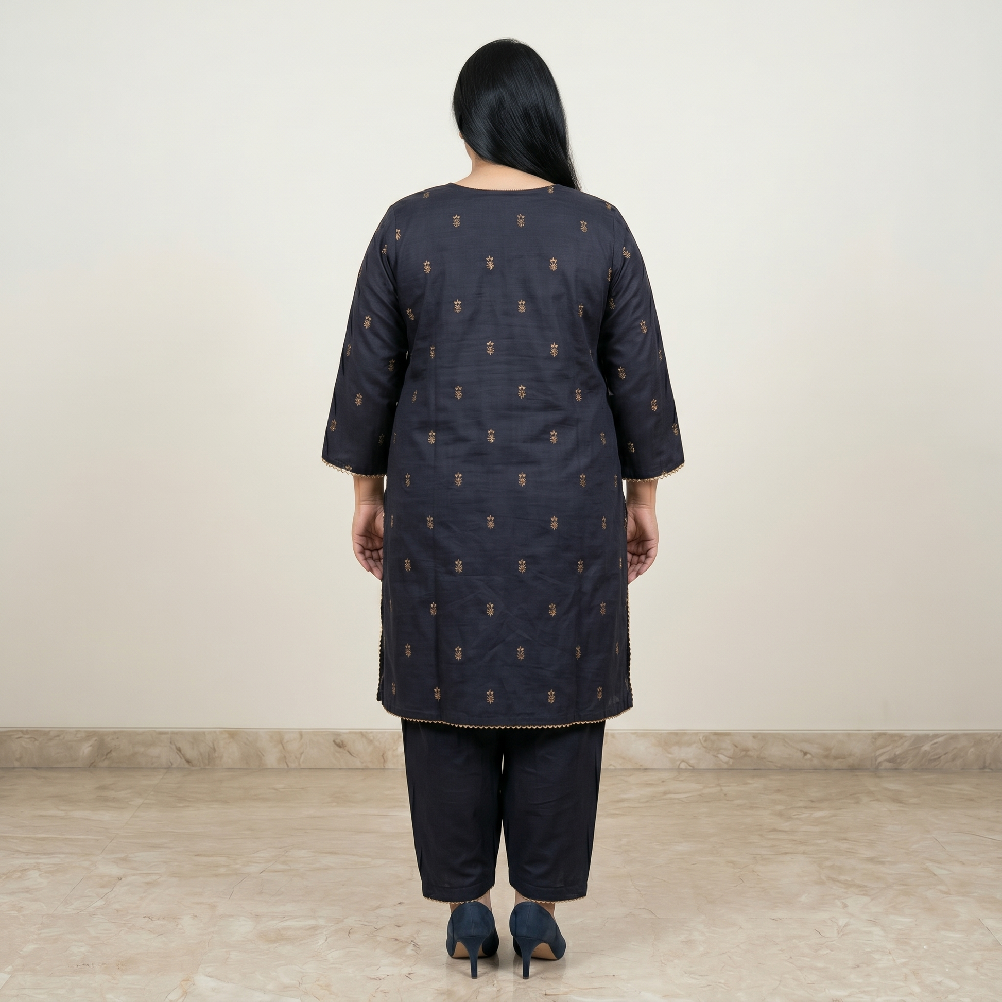 Woman wearing a dark blue kurta with a subtle pattern on a plain background
