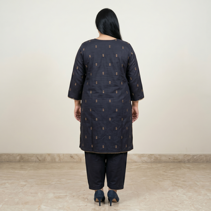 Woman wearing a dark blue kurta with a subtle pattern on a plain background