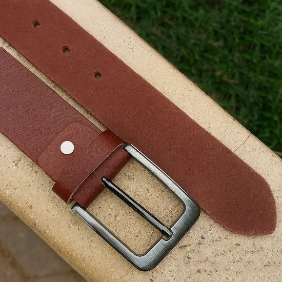 Brown genuine leather belt with matte metal buckle, premium finish, and smooth texture, laid flat on a white background.